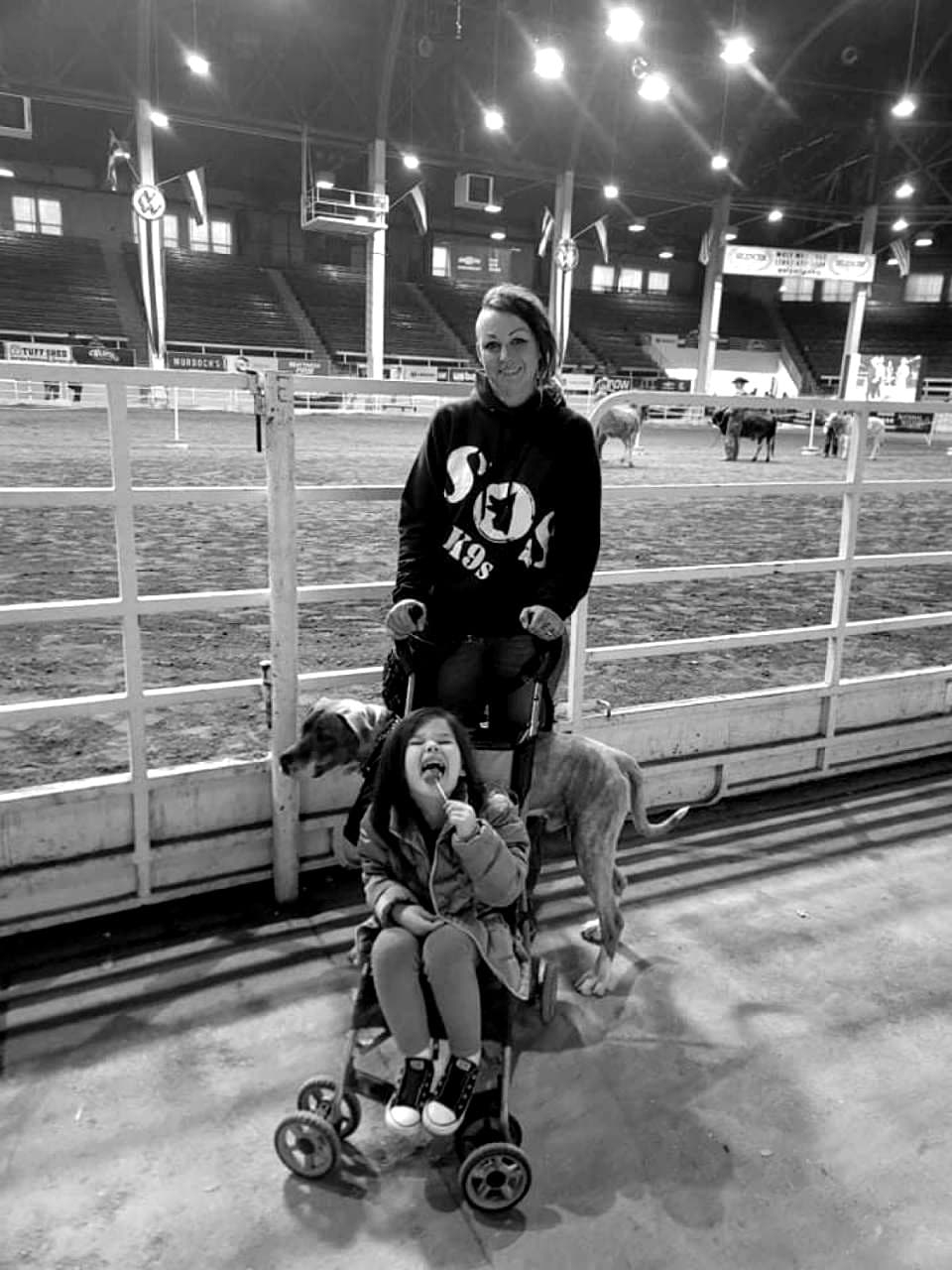 Athena with a child and service dog near arena bleachers